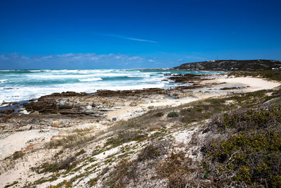Scenic view of beach against blue sky