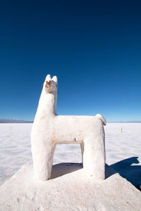 Built structure on beach against clear blue sky