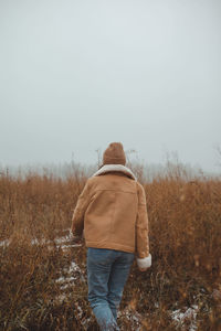 Women standing in a foggy late autumn winter field looking back