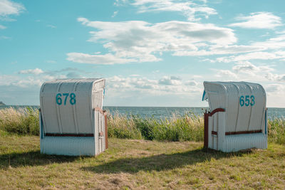 Two white hooded beach chairs on the german island rügen.