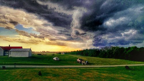 Scenic view of field against cloudy sky