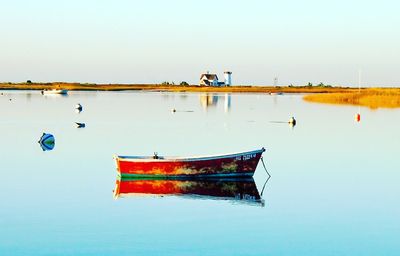 Boat moored on sea against clear sky