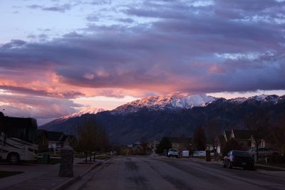 Road and snowcapped mountain against sky during sunset