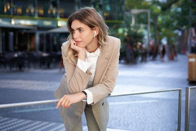 Young businesswoman talking on mobile phone in city