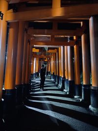 Rear view of man walking in illuminated building