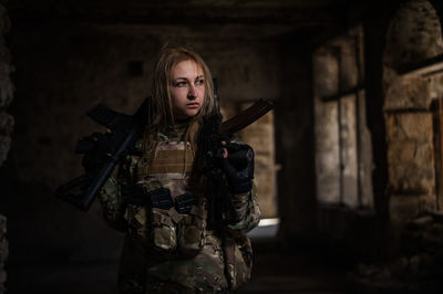 Portrait of young woman standing against wall