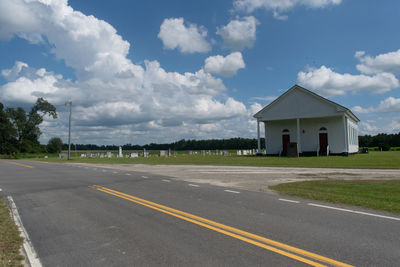 Road by building against sky