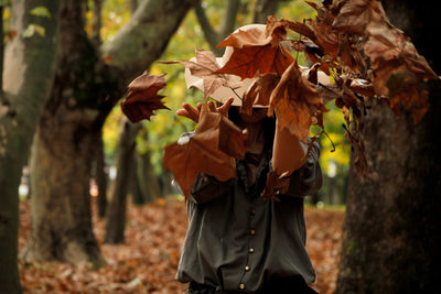 Woman catching dry autumn leaves