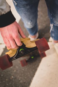 Low section of man holding skateboard