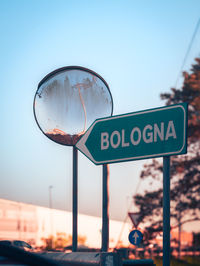 Close-up of road sign against sky