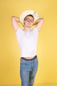 Portrait of smiling man standing against yellow wall