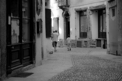 Rear view of people walking in corridor of building