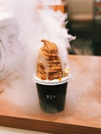 Ice cream with steam in cup on table