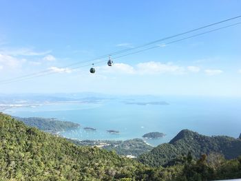 Overhead cable car over sea against sky