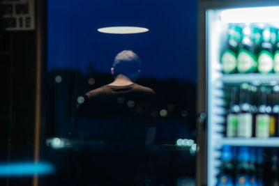 Rear view of woman standing at night