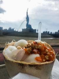 Close-up of dessert in container against sky