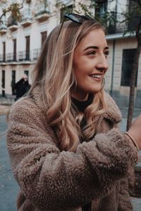 Portrait of smiling young woman in city