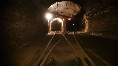 Illuminated railroad tracks in tunnel