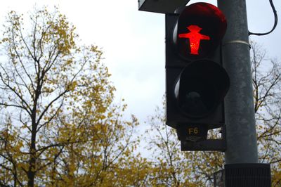 Low angle view of road signal against sky