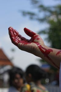 Close-up of hand on red leaf