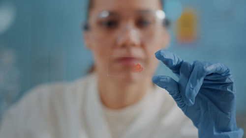 Young scientist holding glass in laboratory