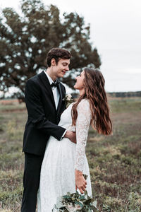 Newlywed couple romancing while standing on land