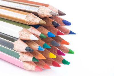 High angle view of multi colored pencils against white background