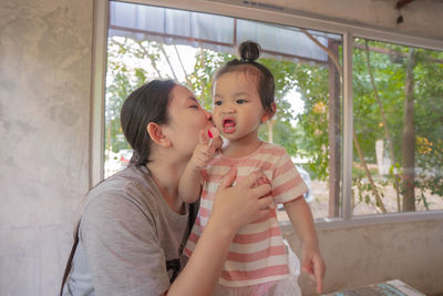 Low angle view of mother and girl on window