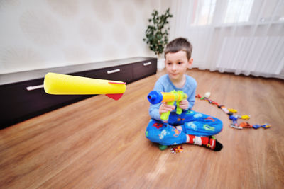 A foam bullet or rocket flies out of a toy machine gun.