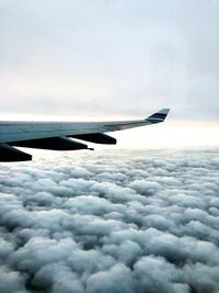 Airplane flying over cloudscape against sky