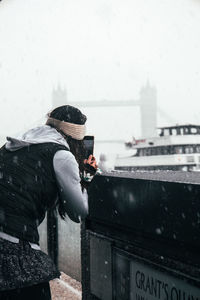 Side view of person standing on snow covered landscape during rainy season