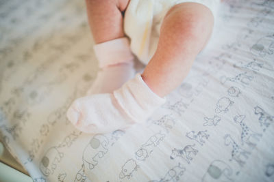 Low section of baby girl in crib