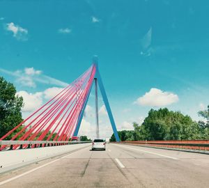 Road by bridge against sky