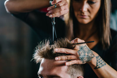 Close-up of woman cutting man hair