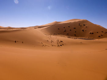 Sand dunes in desert against clear sky