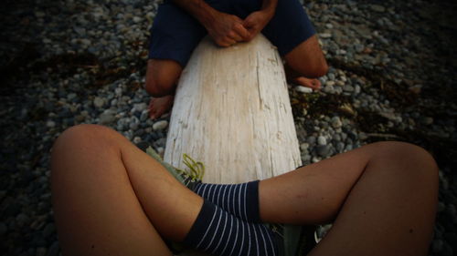 Midsection of woman sitting on rock