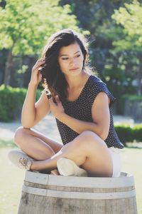 Portrait of beautiful young woman sitting in park