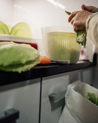 Woman hands cutting and preparing lettuce for a salad at home