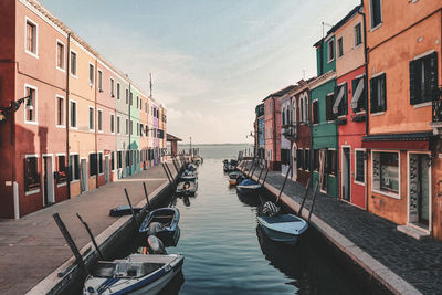 View of the colorful houses and boats along the canal at the island of burano, venice, italy