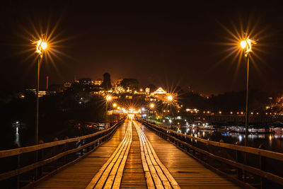 Illuminated light trails on street against sky at night