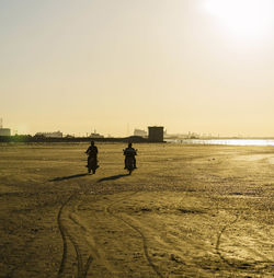 Man on beach against sky during sunset