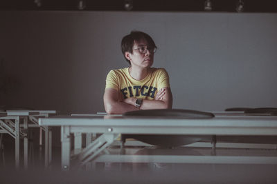 Portrait of boy sitting on table at home