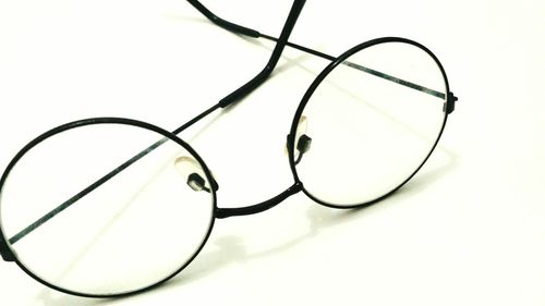 Close-up of eyeglasses on table against white background