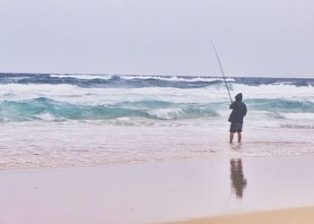 High angle view of people standing on beach