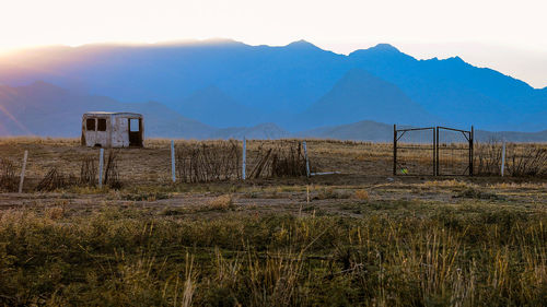 Scenic view of field and mountains against sky