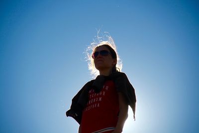 Woman standing against clear blue sky