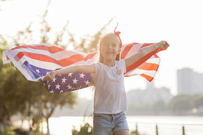 Rear view of woman holding american flag