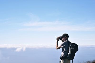 Man photographing against sky