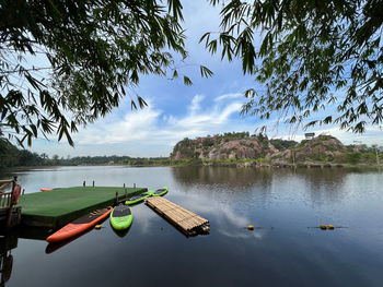 Rear view of man kayaking in lake against sky