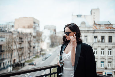 Woman standing on mobile phone in city